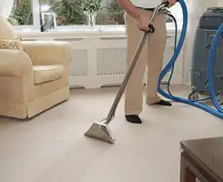 Carpet cleaning professional removing dirt and stains with a hot-water extraction tool in a home, Huntsville, AL.